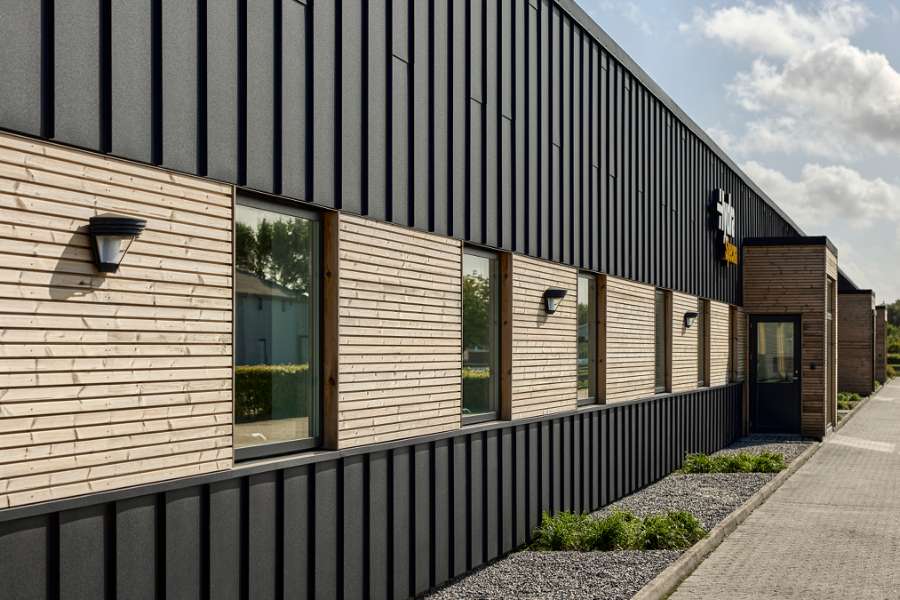 Black steel profiles and warm wood create striking contrasts on headquarters facade, Jernvej 19, 6900 Skjern, Denmark